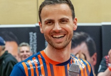 ASC Grünwettersbach beendet Negativserie in der TTBL – Sieg in der ASC-Arena Karlsruhe Smiling man in an orange-and-blue striped jersey holds a microphone at an indoor event.